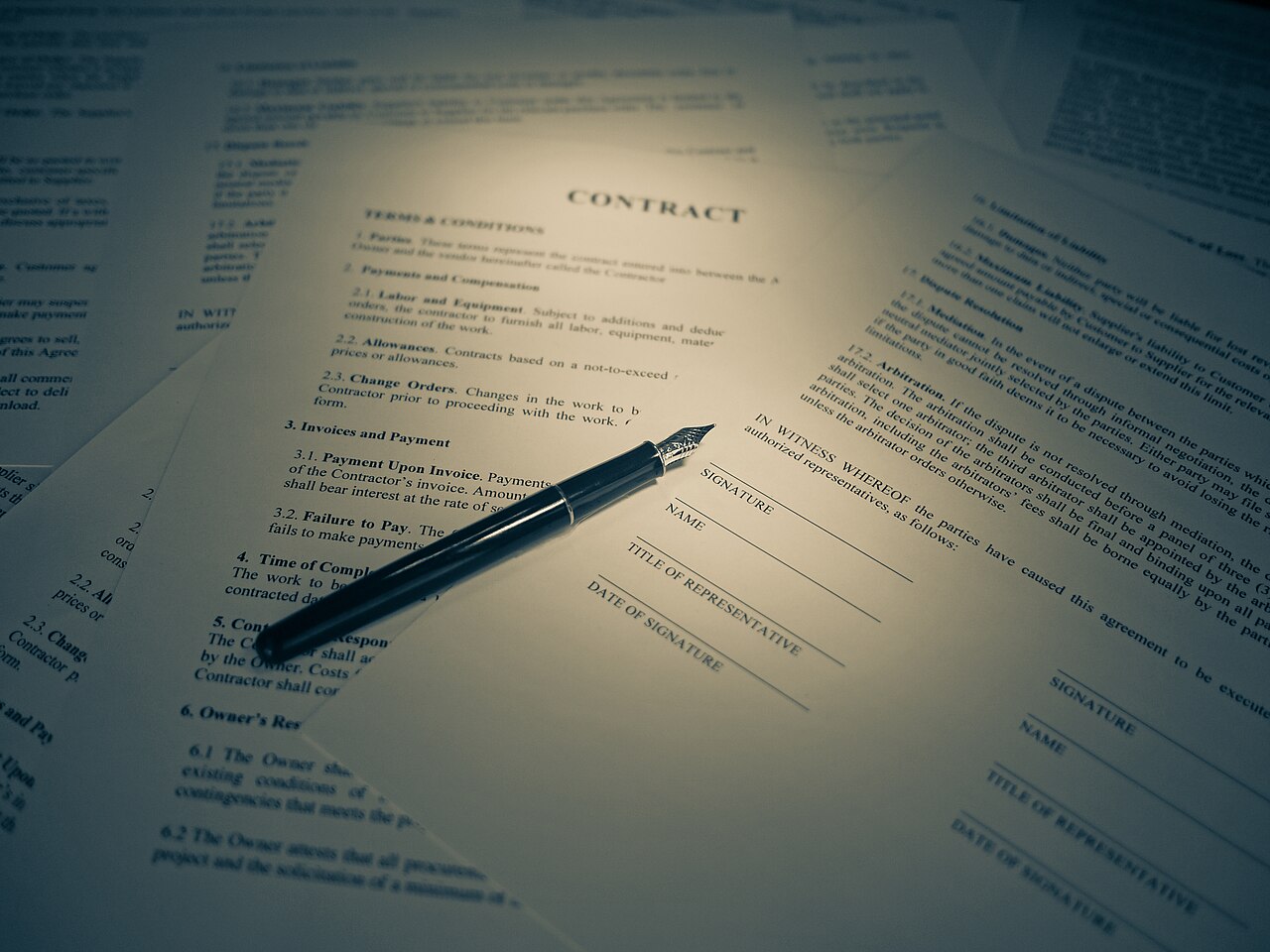 Une main qui signe un document au stylo.